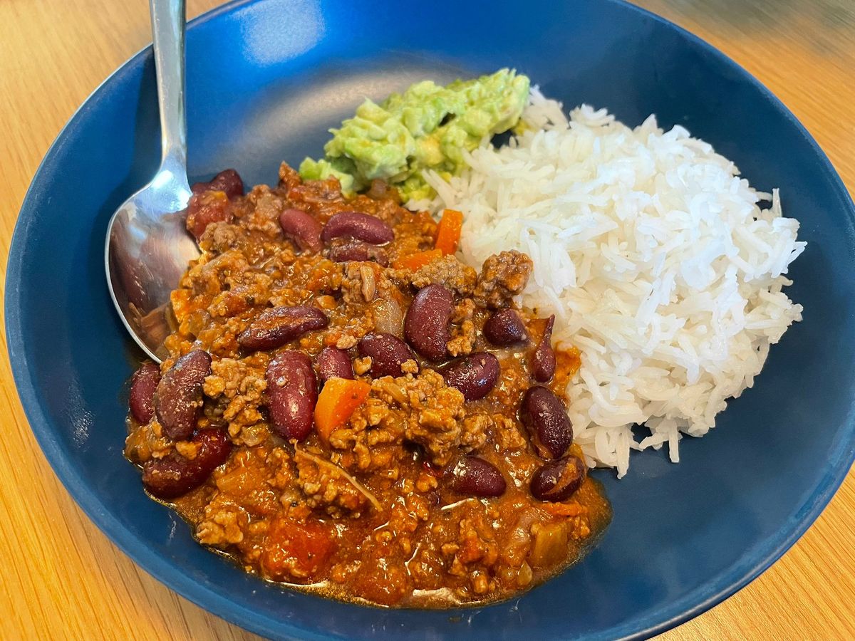 A bowl of rich chilli con carne served over rice